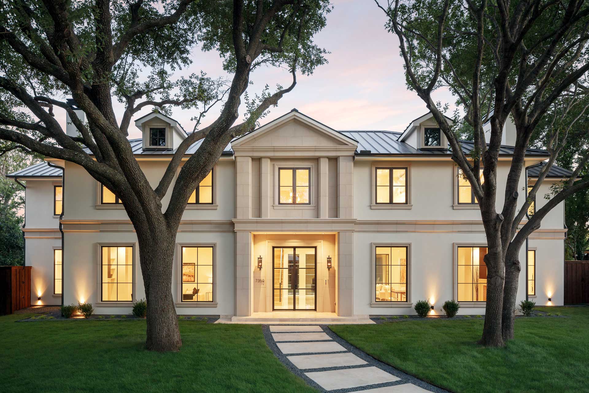 a large white house with trees and grass