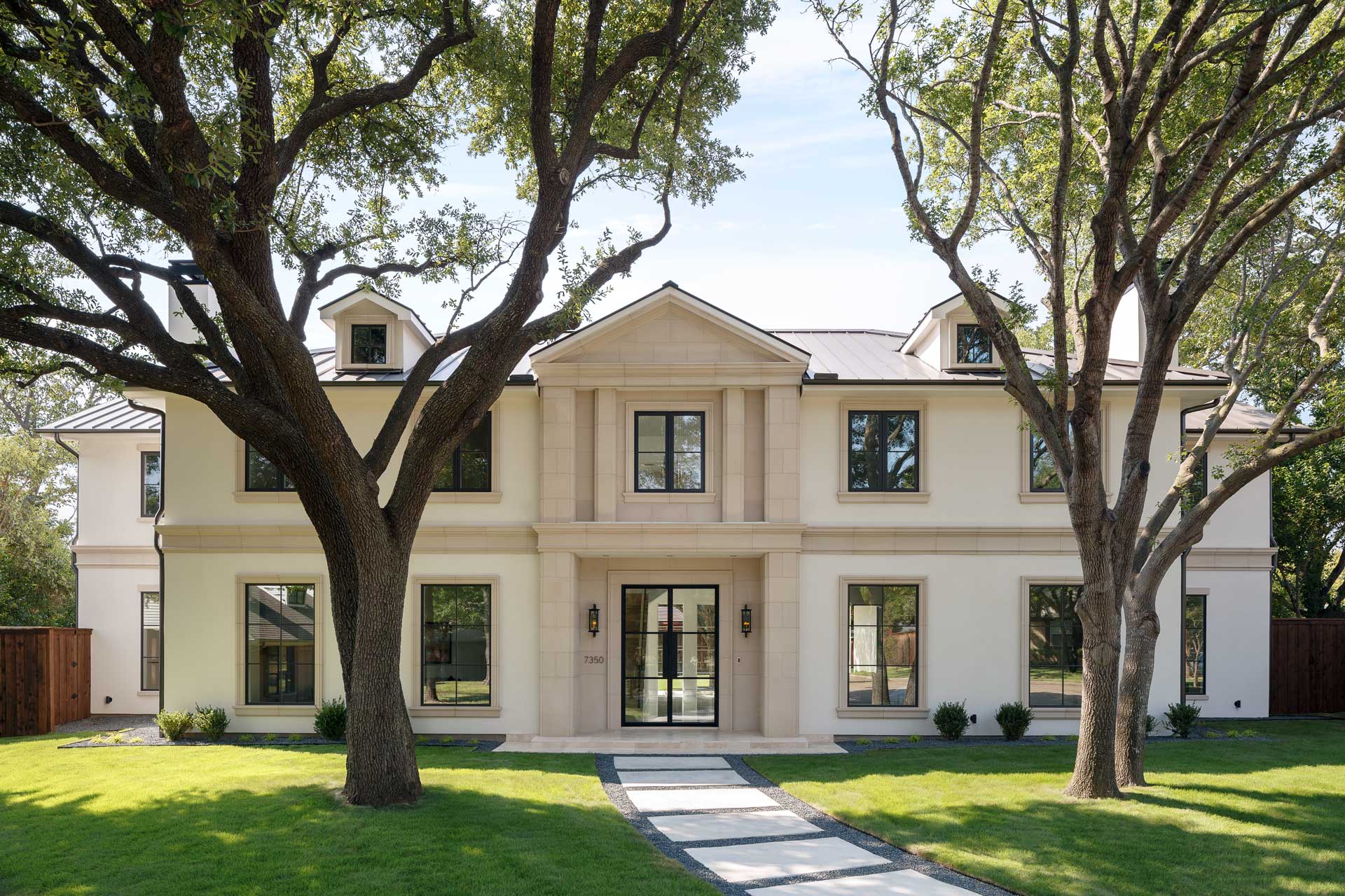a large white house with trees and grass