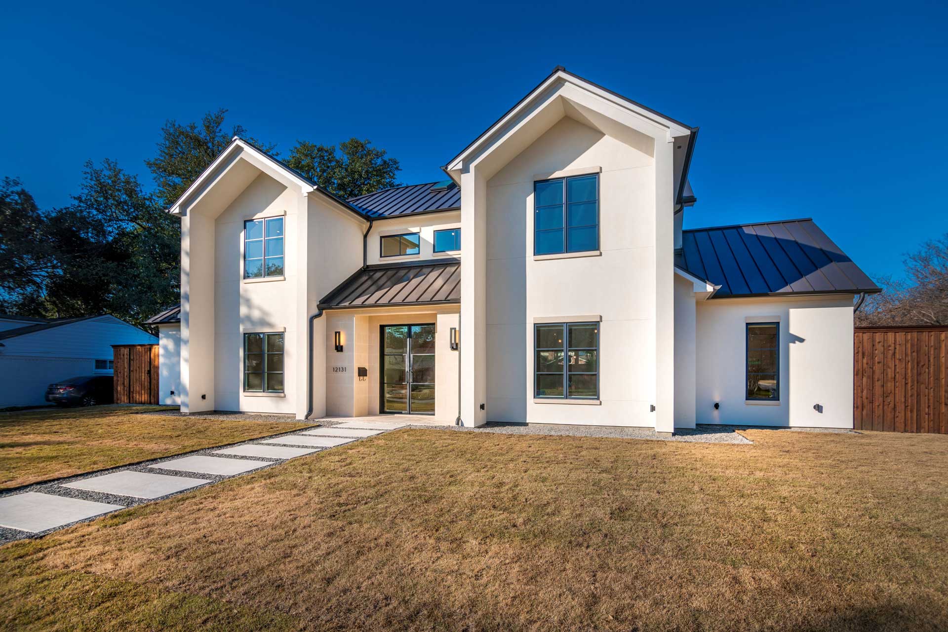 a white house with a lawn and a blue sky