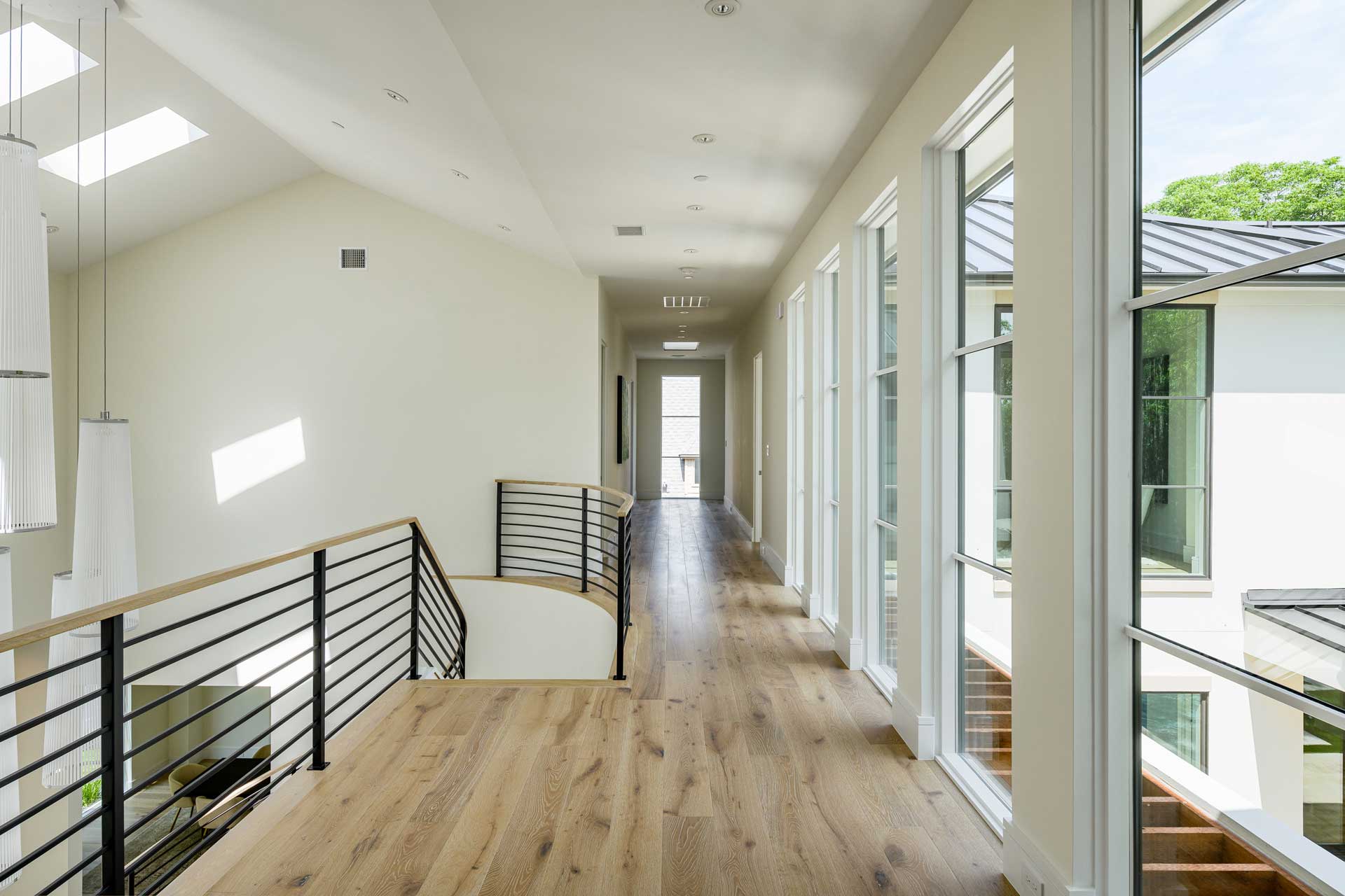 a long hallway with a staircase and windows