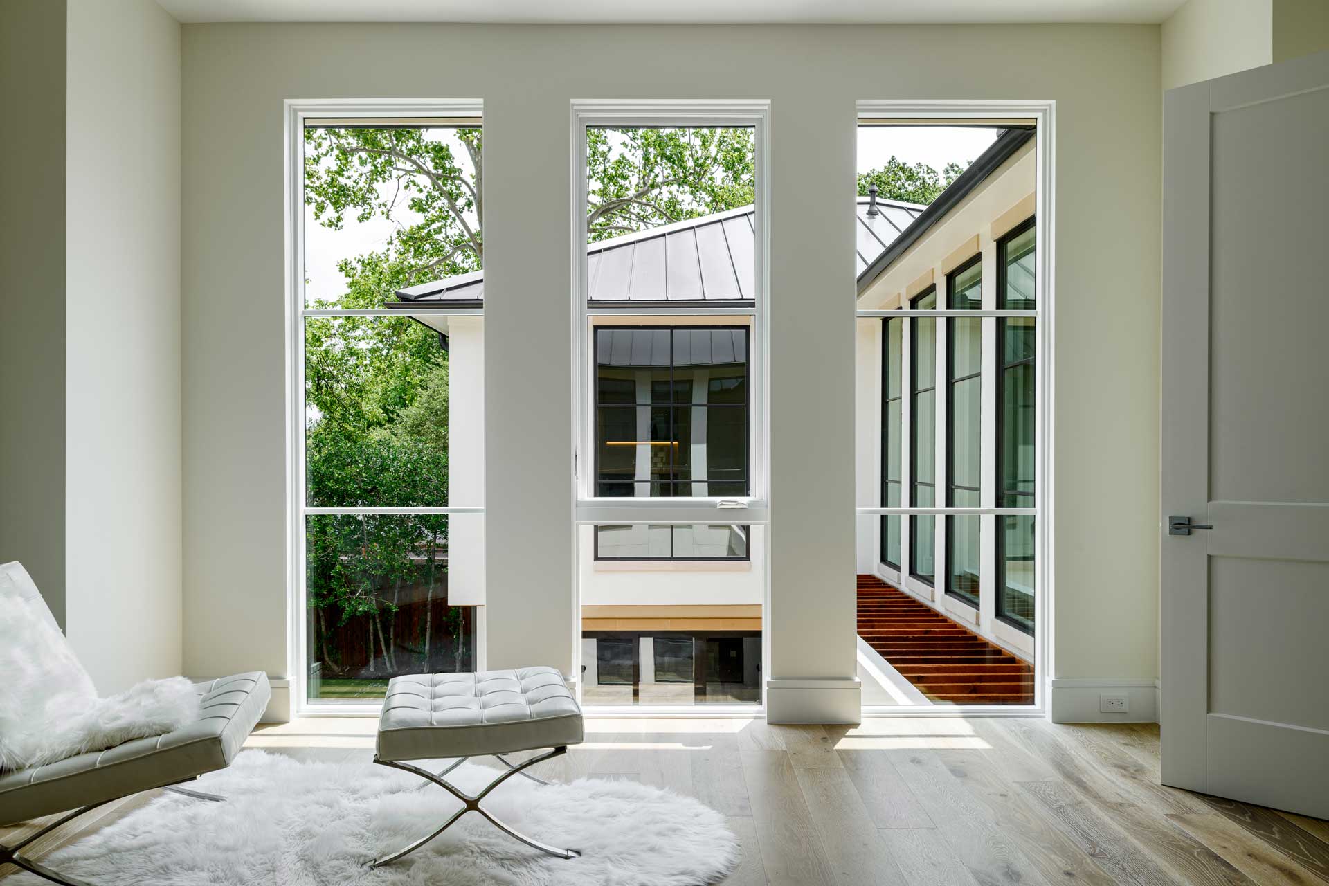 a room with white walls and a white rug and a bench