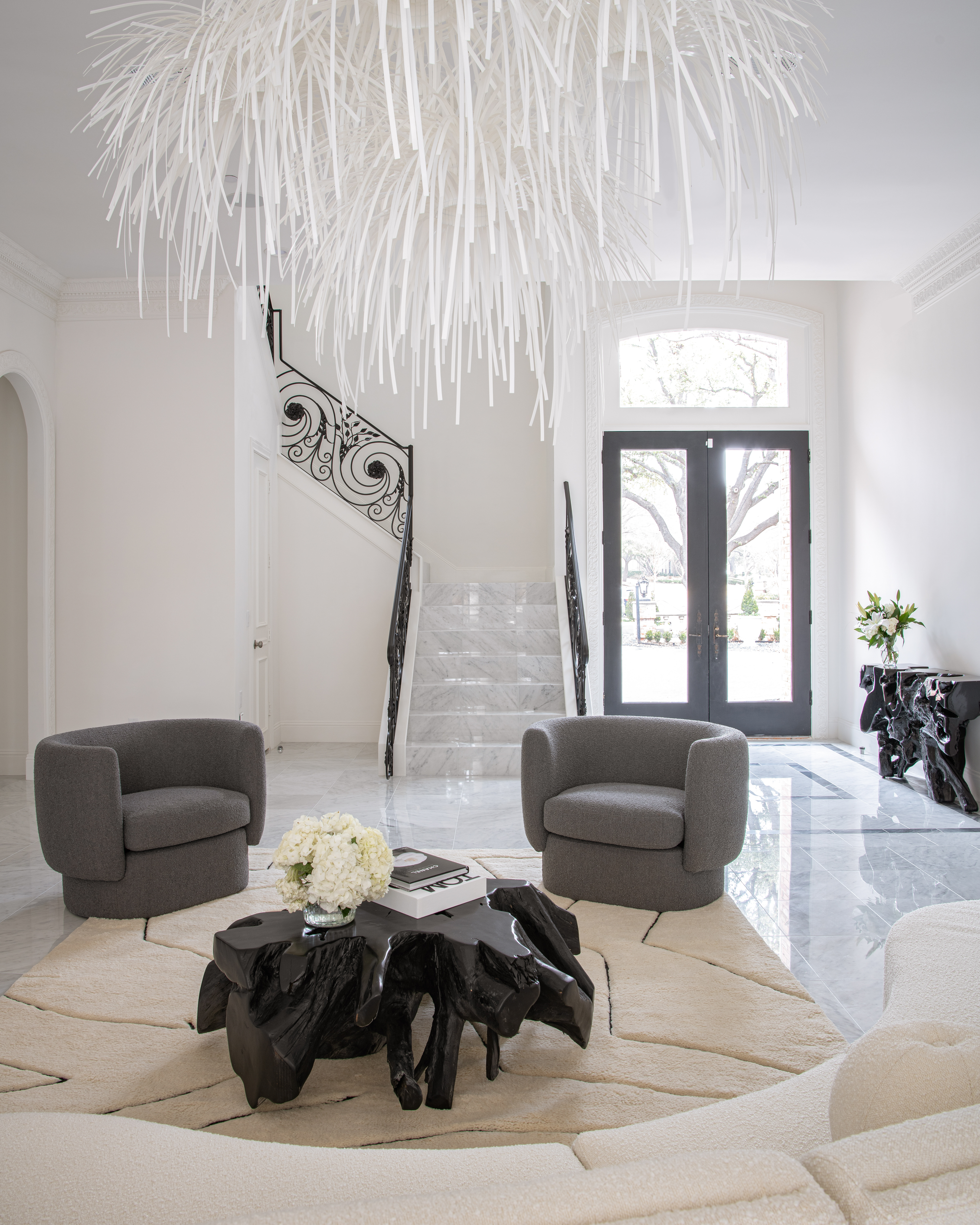 a living room with a chandelier and chairs