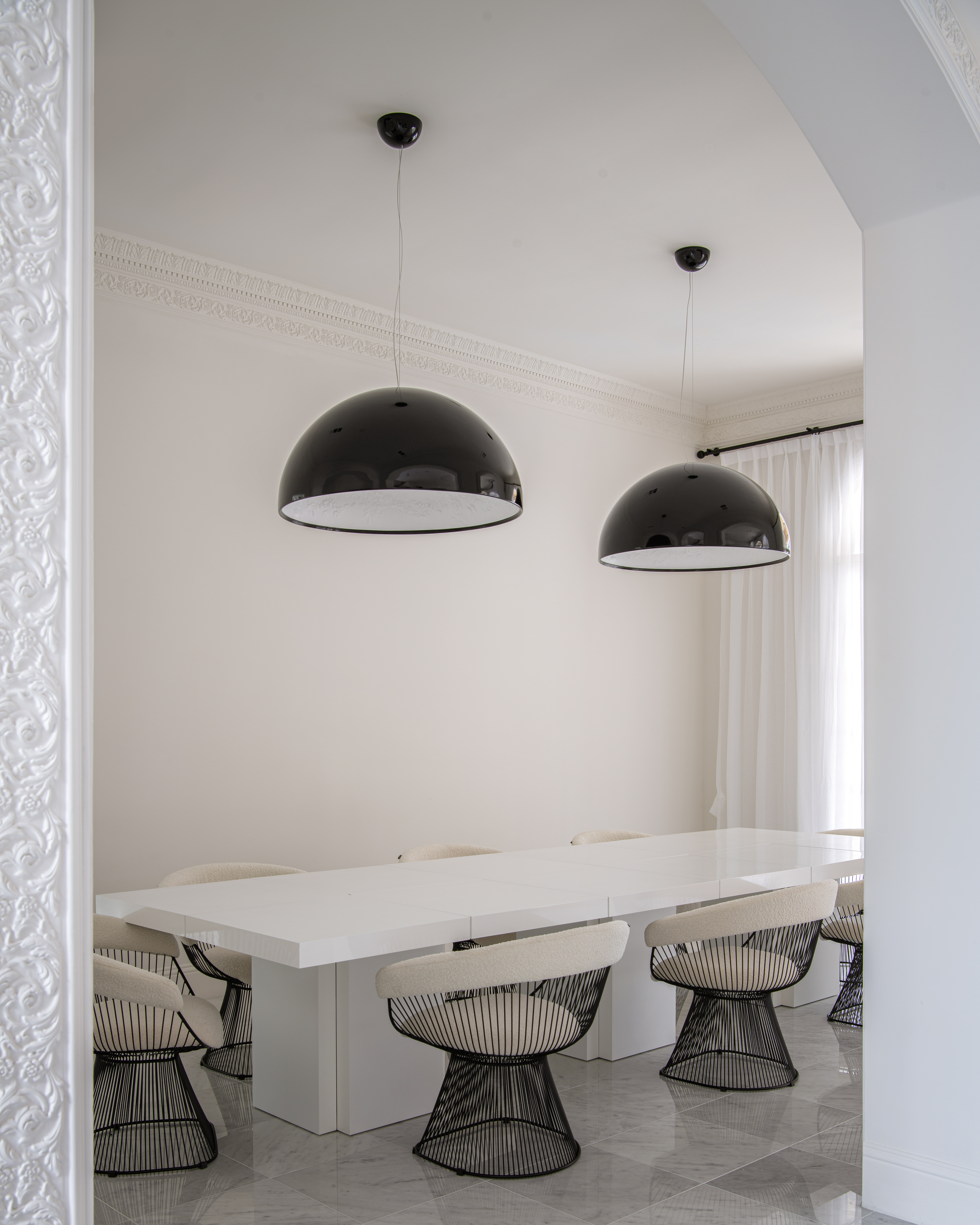 a white table with chairs and black lamps