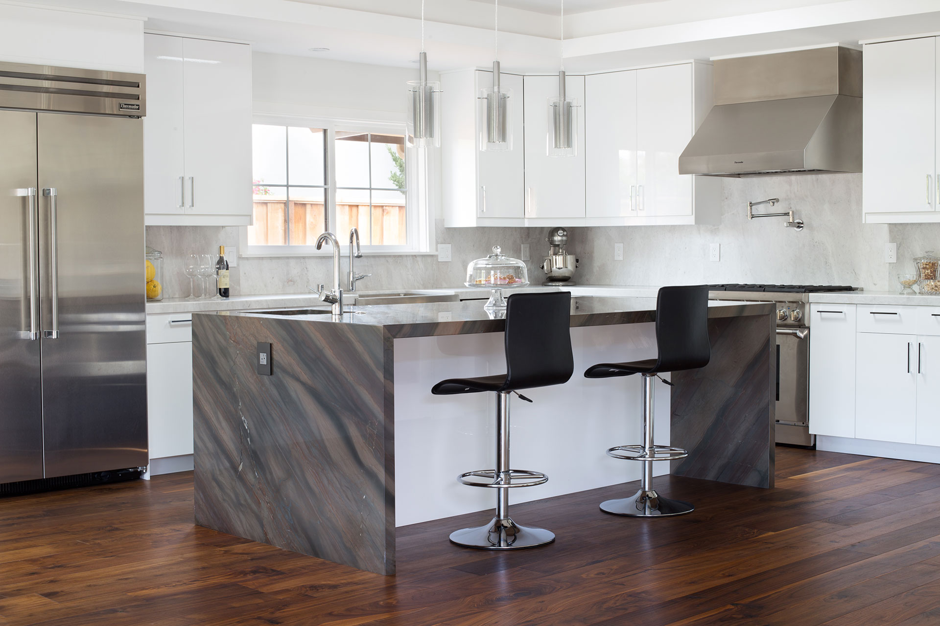 A modern kitchen featuring a spacious island surrounded by stylish bar stools for casual dining and socializing.